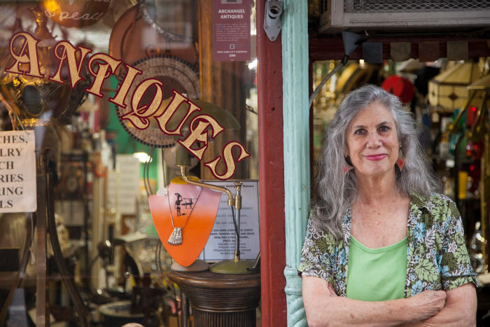 Propellerhead Hosting woman standing outside her antiques store